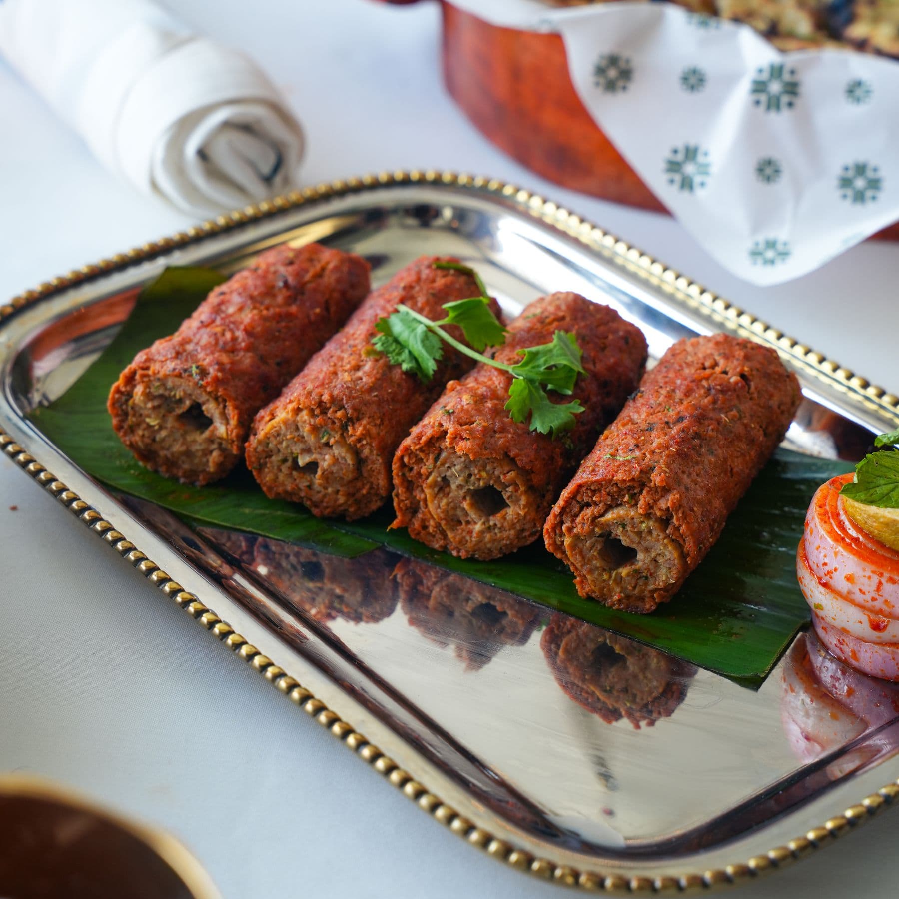 Grilled seekh kebabs on a platter with garnish